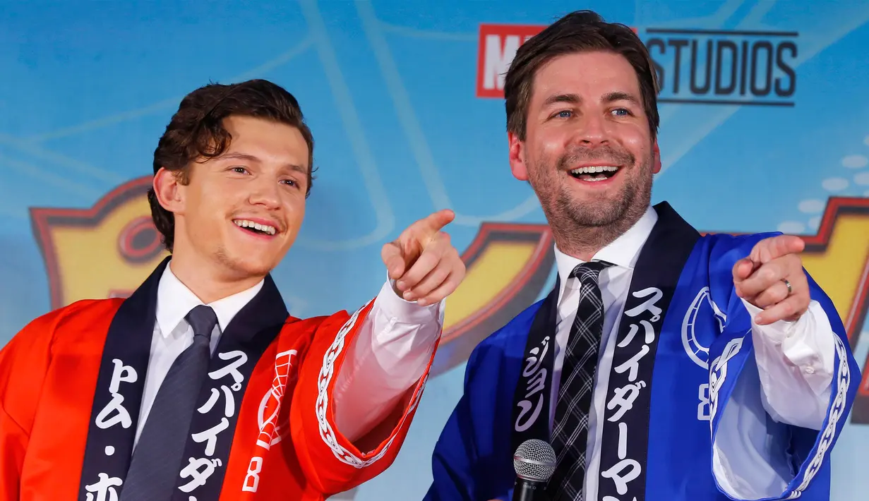 Tom Holland (kiri) kompak dengan sang sutradara Jon Watts menunjuk salah satu penggemarnya yang hadir saat pemutaran perdana filmnya di Tokyo, Senin (7/8). Jepang adalah negara terakhir yang merilis film “Spider-Man: Homecoming”. (Shizuo Kambayashi /AP)