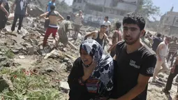 Seorang warga menangis saat dievakuasi polisi ketika terjadi serangan udara Israel di Gaza, Rabu (9/7/14). (REUTERS/Majdi Fathi)