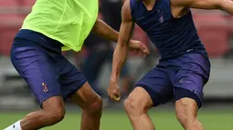 Gelandang Tottenham Hotuspur, Dle Alli (kiri) berusaha merebut bola rekannya Harry Winks selama latihan di Singapura  (19/7/2019). Tottenham akan bertanding melawan Juventus pada International Champions Cup 2019 di National Stadium, Singapura. (AFP Photo/Roslan Rahman)
