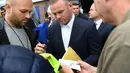 Pemain anyar Everton, Wayne Rooney, memberikan tanda tangan kepada para fans yang menghadiri jumpa pers perkenalan dirinya di Goodison Park, Liverpool, Senin (10/7/2017). (AFP/Paul Ellis)