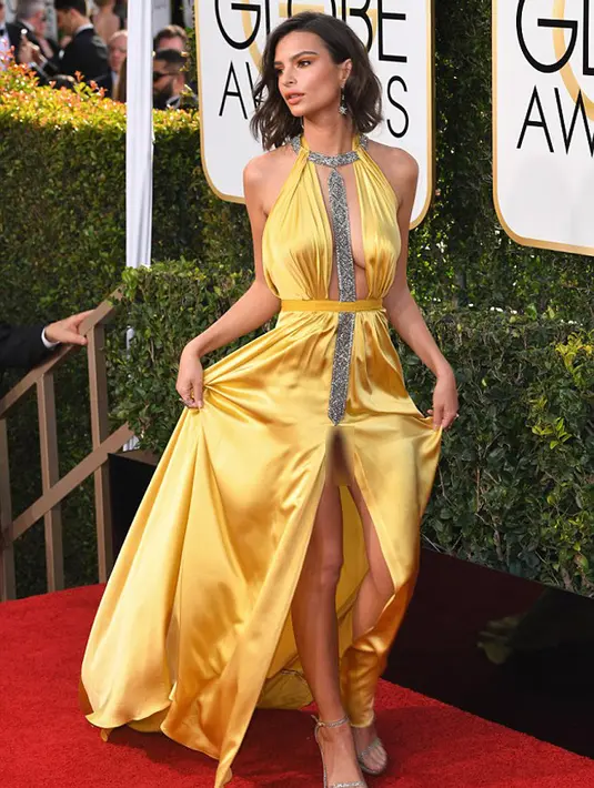 Terlalu asik berpose di hadapan kamera para media, Emily tidak menyadari belahan gaunnya yang cukup tinggi di bagian depan menyebabkan pakaian dalamnya terlihat dan tertangkap kamera. (doc.dailymail.com)