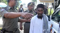 Petugas Satpol PP Kota Bogor mengamankan pengemis yang sempat viral di kawasan perempatan Yasmin, Bogor, Jawa Barat, Rabu (20/3). Pengemis tersebut mengakui jika berangkat mengemis dengan menaiki mobil, namun hanya menyewa. (merdeka.com/Arie Basuki)