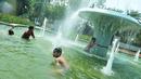 Sejumlah anak mandi di bundaran air mancur Jalan Teuku Umar, Jakarta Pusat, Sabtu (23/9). Cuaca panas ibu kota memaksa anak-anak menceburkan diri di kolam untuk menyejukkan badan. (Liputan6.com/Helmi Afandi)
