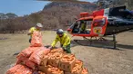 Petugas margasatwa NSW memuat wortel dan ubi jalar untuk walabi korban kebakaran hutan di sepanjang Pantai Selatan New South Wales pada 10 Januari 2020. Cara ini dilakukan karena walabi akan kesulitan mencari makan di saat habitatnya rusak. (STR/NSW NATIONAL PARKS AND WILDLIFE SERVICES/AFP)