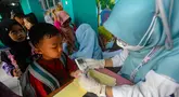 Tenaga medis dari Puskesmas Ciputat melakukan tes gula saat kegiatan pengecekan kesehatan murid di Sekolah Dasar Negeri (SDN) 04 Ciputat, Tangerang Selatan, Banten, Jumat (9/8/2024). (merdeka.com/Arie Basuki)