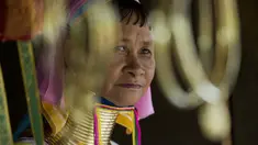 Seorang wanita etnis Kayan duduk di sebuah toko di desa PanPat, Kayan, Myanmar, Rabu (9/9/2015). Kaum perempuan Suku Kayan ini mengenakan banyak kalung berbentuk cincin di lehernya hingga membuat leher mereka panjang. (AFP PHOTO/Ye Aung THU)