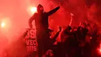 Pendukung Paris Saint-Germain menyalakan suar atau flare saat pertandingan melawan Real Madrid di stadion Parc des Princes di Paris (6/3). Dalam pertandingan ini PSG kalah 1-2 atas Real Madrid. (AFP Photo/Franck Fife)