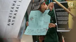 Seorang mahasiswa membawa poster saat menggelar aksi di depan Gedung KPU, Jakarta, Selasa (23/4). Dalam Aksi #Mahasiswakawalkpu tersebut mendesak KPU RI segera menyelesaikan permasalahan pemilu. (Liputan6.com/Faizal Fanani)
