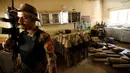 Seorang anggota pasukan kontraterorisme Irak berjaga di bangunan yang digunakan sebagai pabrik senjata militan ISIS yang berhasil ditemukan di Fallujah, Irak, Kamis (23/6). (REUTERS/Thaier Al-Sudani)
