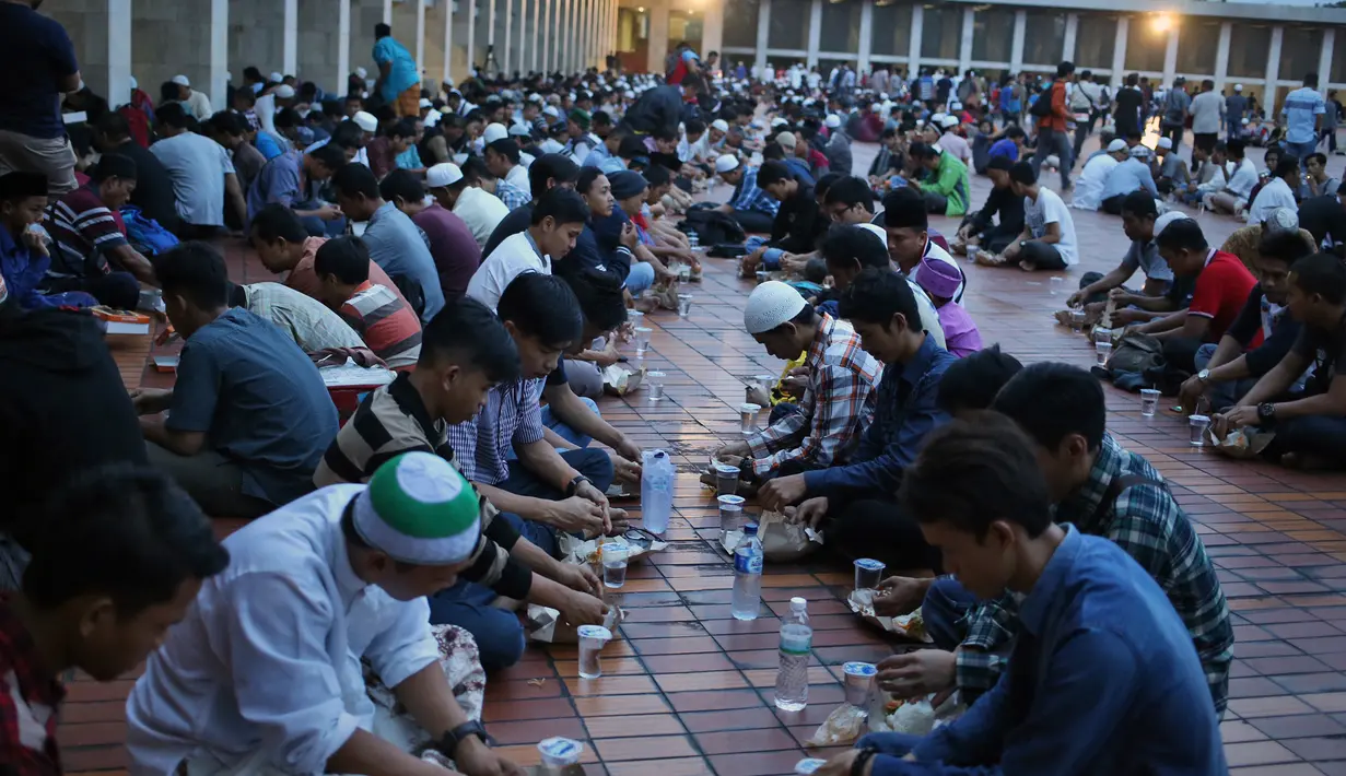Sejumlah orang berbuka puasa di Masjid Agung Istiqlal, Jakarta, Minggu (28/5). Sebanyak 5000 kotak makanan dibagikan untuk berbuka pada hari Jumat - Minggu. (AP Photo / Dita Alangkara)