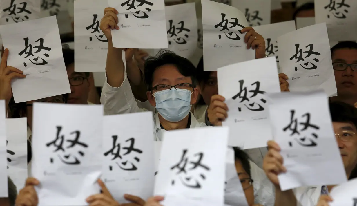 Ratusan dokter membawa kertas saat menggelar aksi protes di dalam sebuah rumah sakit di Hong Kong, Rabu (21/10). Ratusan dokter umum tersebut menuntut kenaikan gaji sejalan dengan kenaikan upah pegawai negeri di kota itu. (REUTERS/Bobby Yip)