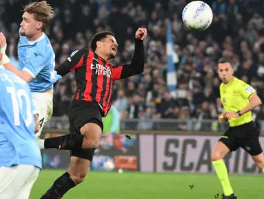 Bek AC Milan asal Swiss, Zachary Athekame (tengah) berebut bola dengan penyerang Lazio asal Denmark, Gustav Isaksen (kedua kiri) selama pertandingan pekan ke-29 Serie A Italia 2025/2026 di Olimpico Stadium, Roma, Minggu 15 Maret 2026 waktu setempat atau Senin (16/3/2026) dini hari WIB. Peluang AC Milan memangkas jarak dengan Inter Milan di klasemen Serie A 2025/2026 kandas. (Alberto PIZZOLI/AFP)