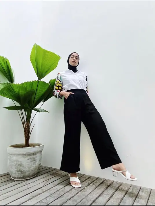 Kemeja putih dengan detail motif lucu di lengan sangat cocok untuk dipadu padankan dengan celana dan jilbab hitam, lho. (instagram/ayudiac)