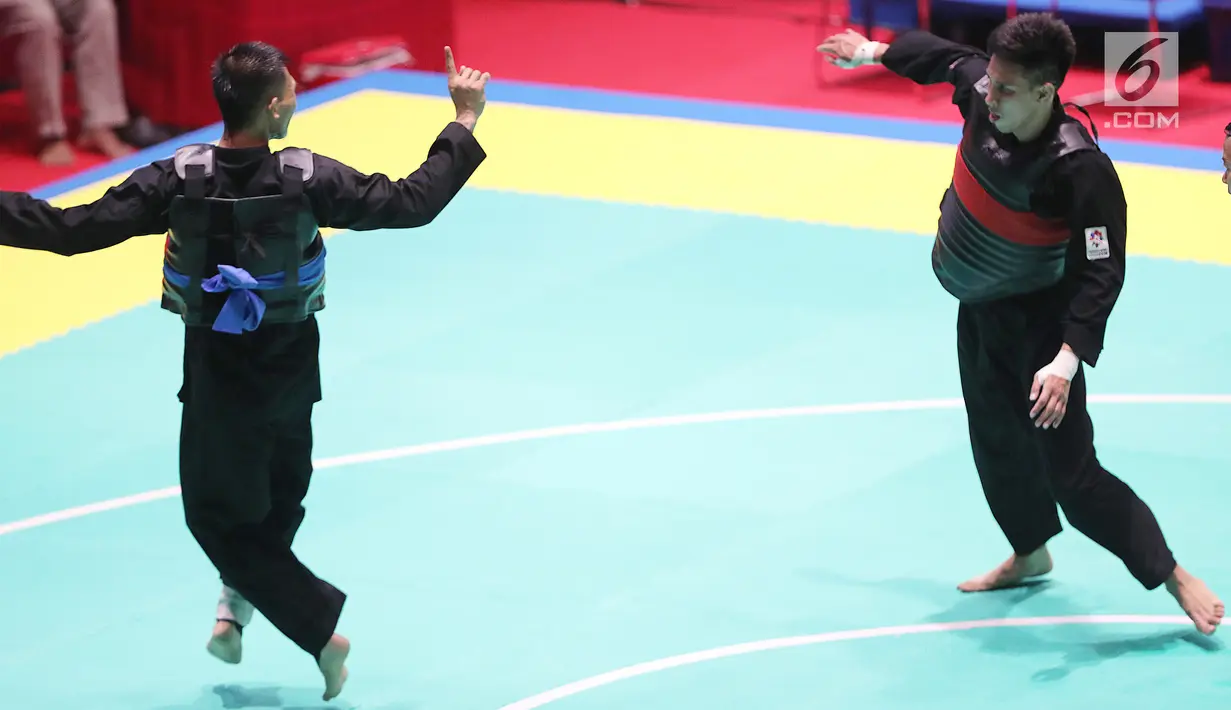 Pesilat Indonesia, Iqbal Candra Pratama saat bertarung melawan Pesilat Thailand, Porntep Poolkaew di Arena Pendopo Pencak Silat TMII, Jakarta, Kamis (23/8). Pesilat Iqbal unggul dengan skor 5-0 dan maju ke 8 besar. (Liputan6.com/Fery Pradolo)