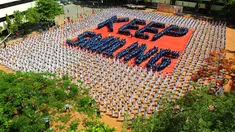 Ribuan pelajar India membentuk formasi saat melakukan senam yoga di Chennai, India, Senin (20/6). Kegiatan ini untuk memeriahkan perayaan Hari Yoga Internasional. (AFP PHOTO/ Arun Sankar)