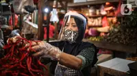 Salah satu pedagang menggunakan face shield dan sarung tangan saat melayani pembeli di Pasar Senen, Jakarta, Senin (1/6/2020). Kementerian Perdagangan menyiapkan pedoman bagi penyelenggara kegiatan perdagangan untuk diterapkan pada saat kenormalan baru (new normal). (Liputan6.com/Faizal Fanani)