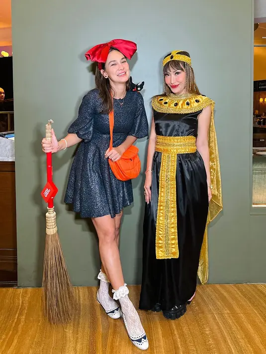 Ayu Dewi dengan kostum Cleopatra. Dress hitam tanpa lengan dengan cape dan belt kuning, yang serasi dengan hiasan kepalanya, penampilan Ayu Dewi tak kalah memesona di sini. [Foto: Instagram/mrsayudewi]