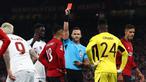 Wasit Ivan Kruzliak (tengah), memberikan kartu merah kepada pemain MU, Casemiro (tiga kiri), setelah melanggar pemain Galatasaray dalam pertandingan lanjutan Grup A Liga Champions 2023/2024 yang berlangsung di Old Trafford, Manchester, Rabu (4/10/2023) dini hari WIB. (AFP/Darren Staples)