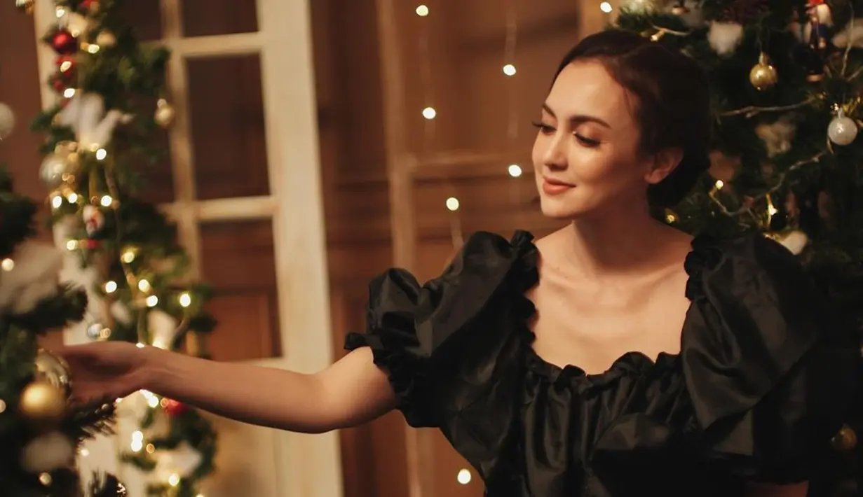 Menyambut perayaan Natal, Rianti Cartwright menjalani sebuah pemotretan. Ia tampak menawan dan simpel mengenakan dress berwarna hitam. Terlihat pula dekorasi pohon natal berwarna hijau dengan pernak-pernik meriah. (Liputan6.com/IG/@riantic)