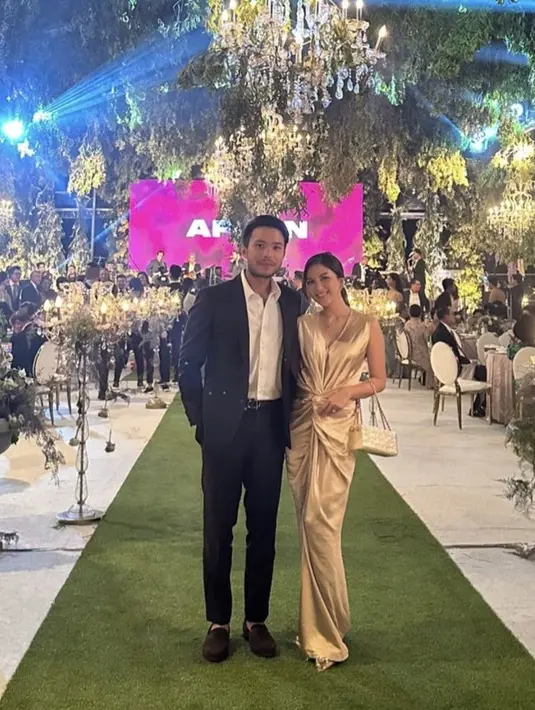 Jessica pun tampil dengan dress panjang bodycon gold dengan ikatan di bagian perut. Dipadukan heels sambil membawa mini bagnya. [@jscmila]