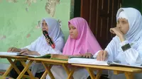 Nanik Nurhayati (Kiri) sedang membaca Al-Qur'an Braille di Pondok Pesantrean KH. Ahmad Dahlan. (Hermawan Arifianto/Liputan6.com )