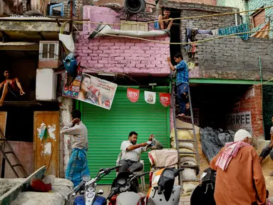 Pekerja migran dari India bagian timur bersiap di luar tempat tinggal mereka yang sempit di pondokan tuga di New Delhi, Rabu (10/10). Sekitar 800 juta warga India hidup dalam kemiskinan. (AP Photo / R S Iyer)