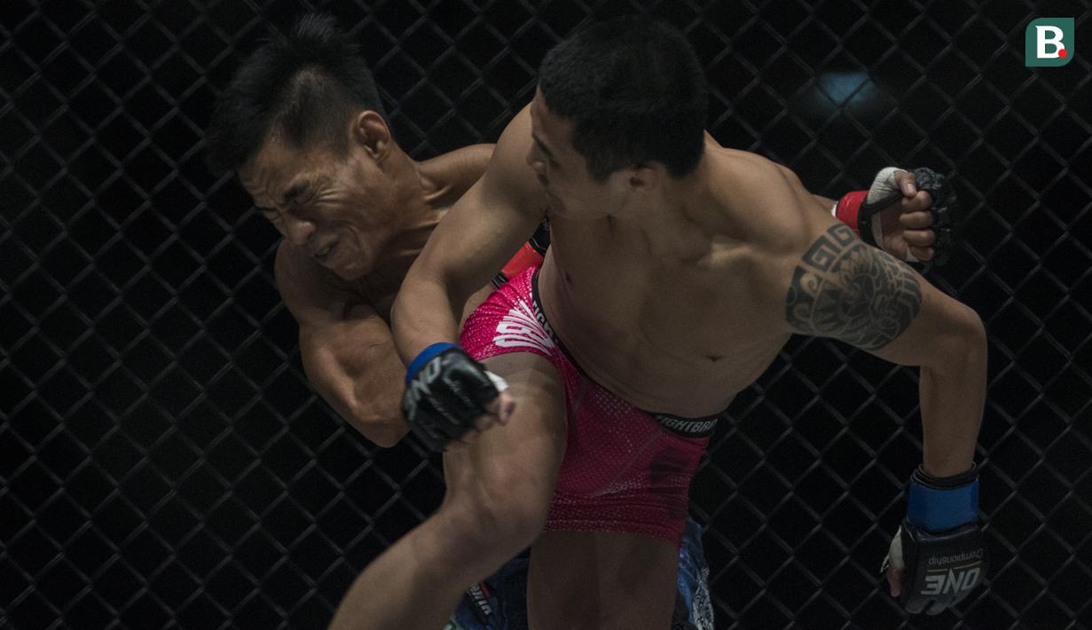 Atlet MMA Indonesia, Stefer Rahardian, terkena pukulan atlet MMA China, Peng Xue Wen, pada kelas strawweight di JCC Senayan, Jakarta, Sabtu (22/9/2018). Stefer Rahardian kalah dari Peng Xue Wen. (Bola.com/Vitalis Yogi Trisna)