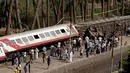 Sejumlah warga melihat gerbong kereta penumpang usai tergelincir saat melintasi jalur di daerah al-Badrasheen, Giza, Mesir, (13/7). Dalam kejadian tersebut, tidak ada korban jiwa dan sekitar 55 penumpang terluka. (AFP Photo/Stringer)