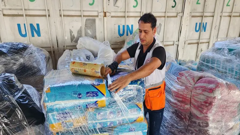 Seorang pekerja PBB menyiapkan bantuan untuk didistribusikan kepada warga Palestina di gudang UNRWA di Deir Al-Balah, Jalur Gaza, pada 23 Oktober 2023. (AP)
