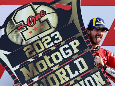 Pembalap Ducati Lenovo, Francesco Bagnaia, merayakan kemenagan dirinya sebagai juara dunia MotoGP 2023 setelah berhasil finis posisi pertama pada balapan MotoGP Valencia, Minggu (26/11/2023). (AFP/Jose Jordan)