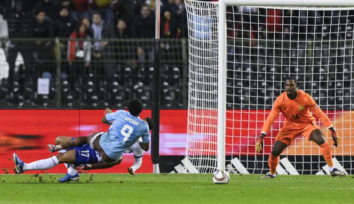 Pemain Belgia, Lois Openda (depan) dilanggar oleh pemain Prancis, William Saliba di dalam kotak penalti pada laga lanjutan UEFA Nations League A grup 2 yang berlangsung di King Baudouin stadium, Brussels, Belgia, Selasa (15/10/2024) dini hari WIB. (AFP/John Thys)