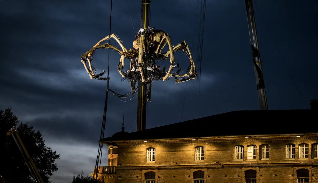Robot mekanik laba-laba raksasa Ariane melakukan pertunjukan dari atap Hotel-Dieu pertunjukan di Toulouse, Prancis pada 1 November 2018. Pertunjukkan "Le Gardien du Temple" itu dilakukan oleh perusahaan teater, La Machine. (ERIC CABANIS / AFP)