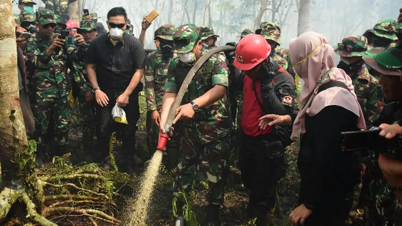 Panglima TNI Marsekal Hadi Tjahjanto meninjau dan ikut menyiram lahan terbakar di Bengkalis.