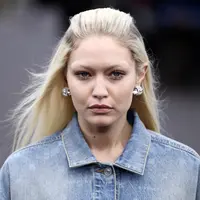 Gigi Hadid mengenakan kreasi untuk koleksi busana ready-to-wear Spring/Summer 2023 dari Givenchy yang dipresentasikan selama Paris Fashion Week di Paris pada Minggu, 2 Oktober 2022. Rambut pirang cerah milik Gigi ditata dengan cara yang sama dengan milik Bella saat ia menambahkan sepasang anting perak kecil tapi tebal. (AFP/Julien De Rosa)