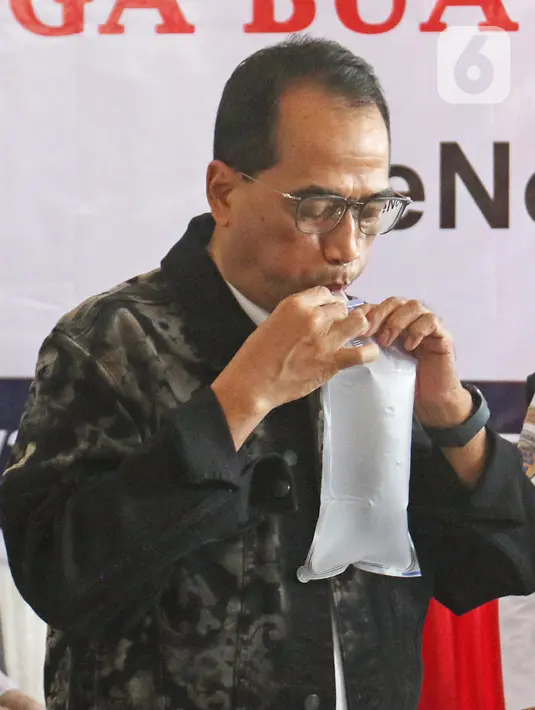 Menteri Perhubungan Budi Karya Sumadi menghembuskan nafasnya pada kantong nafas untuk dites dengan GeNose C19 di Terminal Kampung Rambutan, Jakarta, Minggu (24/1/2021). Penggunaan GeNose C19 untuk penumpang di terminal dan stasiun kereta mulai 5 Februari 2021. (Liputan6.com/Herman Zakharia)