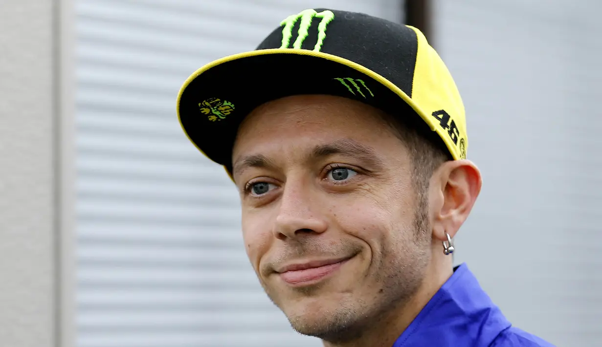 Pebalap Yamaha Movistar, Valentino Rossi, melempar senyum saat mendatangi paddock di Sirkuit Motegi, Tochigi Prefecture, Kamis (12/10/2017). MotoGP Jepang akan bergulir pada Minggu ini. (AP/Shizuo Kambayashi)