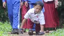 Mukhlis Abdul Holik (8) menuju sekolahnya di Kampung Cikiwul Tonggoh, Sekarwangi, Sukabumi, Kamis (15/11). Dengan penuh semangat dan percaya diri, bocah 8 tahun ini sehari-hari harus merangkak sejauh 3 km menuju SDN 10 Cibadak. (Merdeka.com/Arie Basuki)