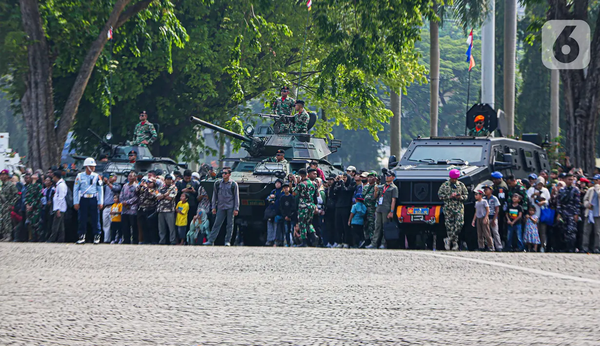 Setelah melalui pengecekan tubuh di gerbang, pengunjung memasuki Lapangan Silang Monas. Banyak yang menggunakan atribut pakaian ala seragam TNI, dari anak kecil hingga dewasa. (Liputan6.com/Faizal Fanani)