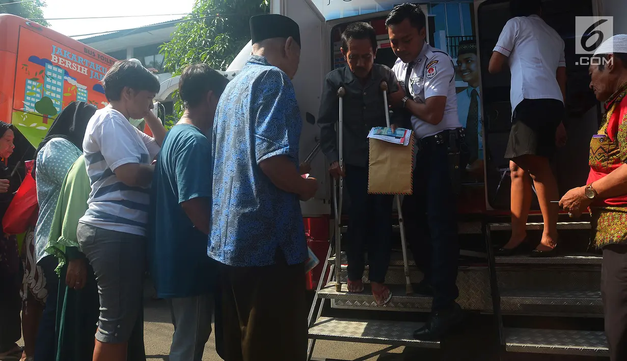 Petugas keamanan membantu warga menuruni tangga saat mengambil Kartu Lansia Jakarta (KLJ) di Kelurahan Tanah Tinggi, Jakarta, Selasa (8/5). Pemprov DKI mendistribusikan tahap pertama KLJ kepada 12.141 penerima. (Merdeka.com/Imam Buhori)