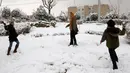 Dua orang anak saling melempar saju di Teheran, Selasa (24/1). Hampir setengah abad salju tak turun di Iran dan sejak 2011 hingga kini salju senantiasa turun di musim dingin. (AFP PHOTO / ATTA KENARE)   