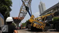 Pekerja mengevakuasi crane yang jatuh di Jalan Kyai Maja, Jakarta Selatan, Kamis (15/10/2015). Alat besar yang tengah melakukan proyek ‎jalan layang ini menimpa salah satu rumah warga yang berada di sisi kanan jalan. (Liputan6.com/Helmi Afandi)