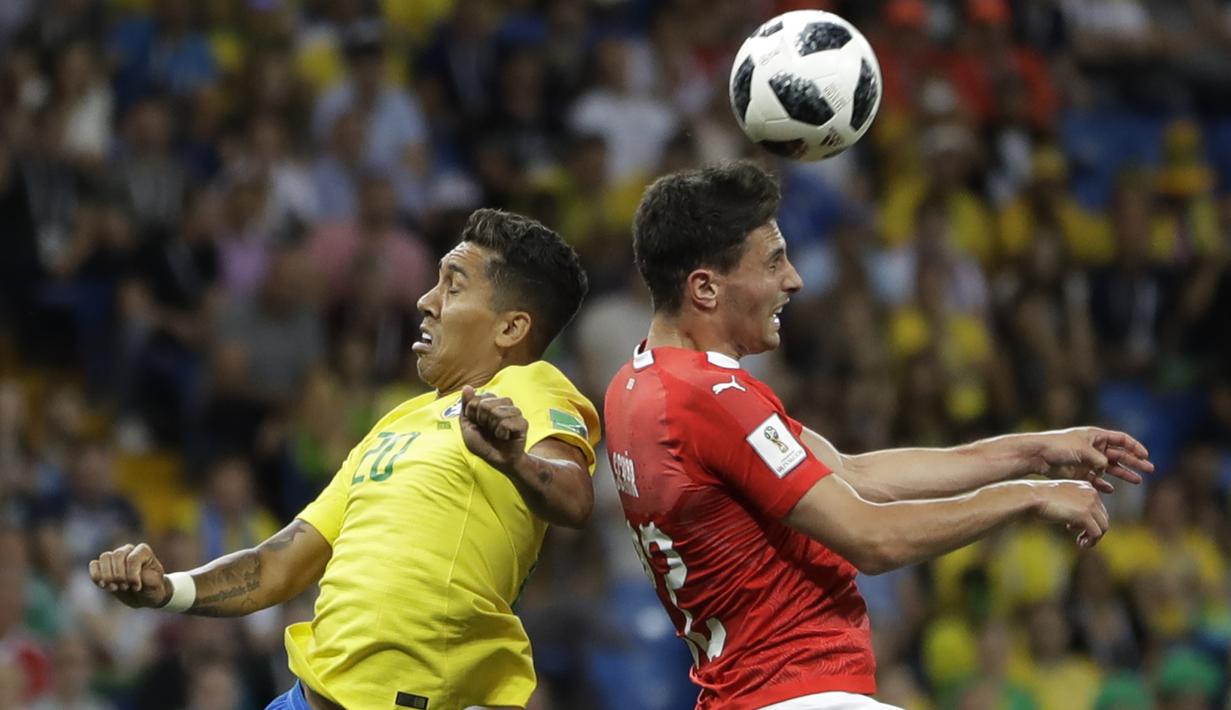 Striker Brasil, Roberto Firmino, duel udara dengan gelandang Swiss, Fabian Schaer, pada laga Grup E Piala Dunia di Rostov Arena, Rostov-on-Don, Minggu (17/6/2018). Kedua negara bermain imbang 1-1. (AP/Andre Penner)