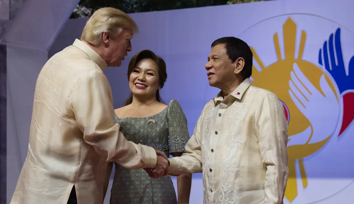 Presiden Filipina, Rodrigo Duterte didampingi Ibu Negara, Cielito "Honeylet" Avancena menyambut Presiden AS, Donald Trump dalam acara makan malam bersama konferensi ASEAN ke-31 di Manila, Minggu (12/11). (Athit Perawongmetha/Pool via AP)