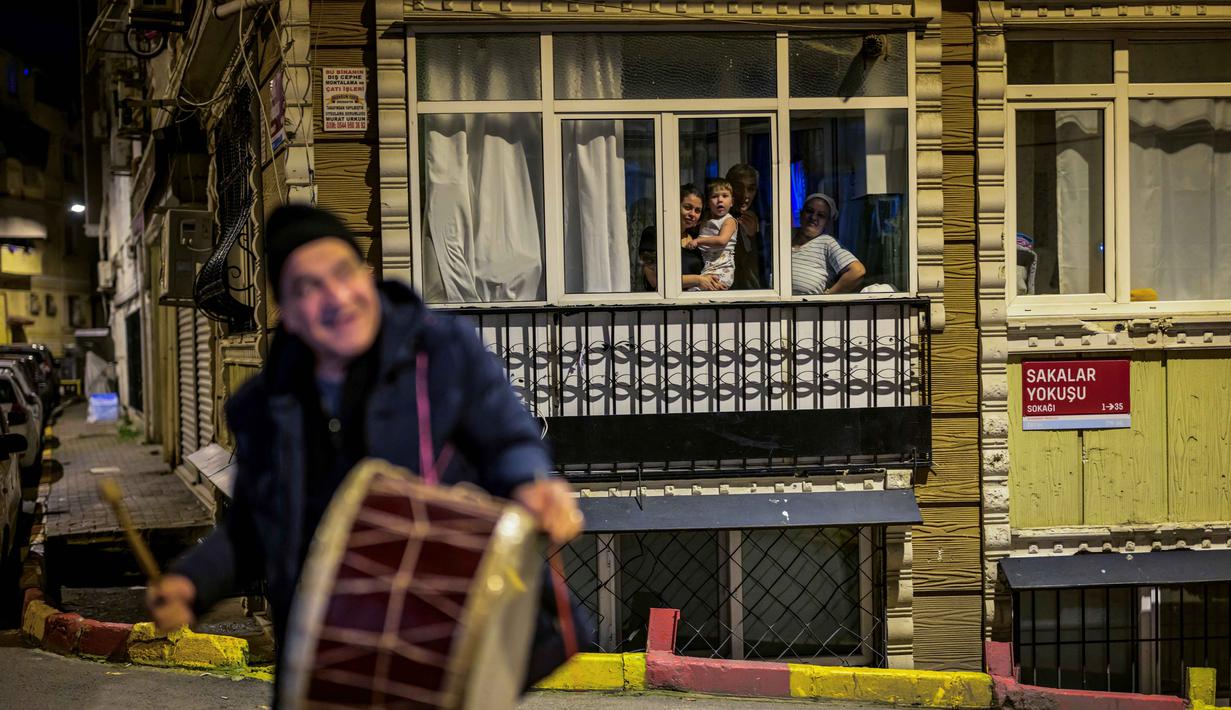 Tradisi yang berasal dari era Ottoman ini adalah salah satu keindahan bulan Ramadan. Tampak dalam foto, penabuh genderang Turki, Hakan Ozbingol, memainkan gendang dan menyanyikan lagu-lagu tradisional di jalanan Istanbul, untuk membangunkan umat Muslim untuk sahur, yaitu makan malam Ramadan, pada 24 Februari 2026. (Yasin AKGUL/AFP)