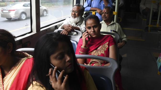 Perempuan bepergian dengan bus  New Delhi Transport Corporation untuk melakukan perjalanan gratis di New Delhi, 29 Oktober 2019. Pemerintahan teritorial ibu kota India, New Delhi, menerapkan kebijakan menggratiskan seluruh rute bus untuk kaum perempuan sejak 29 Oktober. (Sajjad HUSSAIN/AFP)