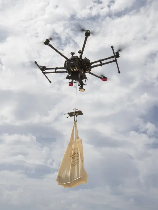 Sebuah drone membawa sekantong makanan dari Cala Tadira dekat Sant Josep de Sa Talaia di Pulau Ibiza, Spanyol, 24 Agustus 2021. Restoran Can Yucas dan perusahaan Galicia Aerocamaras meluncurkan layanan Drone to Yacht untuk mengirim makanan dan minuman eksklusif ke kapal pesiar. (JAIME REINA/AFP)