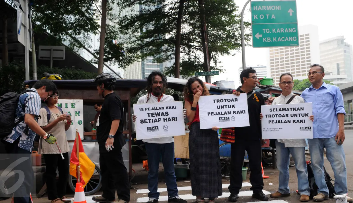 Para Aktivis Pejalan Kaki melakukan Aksi mengecat Jalan sebagai trotoar bagi pejalan kaki di kawasan Tosari, Jakarta, Jumat (11/12). Aksi tersebut di merupakan teguran untuk pemerintah agar serius menangani masalah kecelakaan. (Liputan6.com/Helmi Afandi)