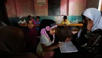 Seorang anak perempuan Kashmir saat membaca Al-Quran di sebuah madrasah lokal selama bulan Ramadan di Srinagar, Kashmir yang dikuasai India, (30/5). Umat muslim di seluruh dunia saat ini tengah menjalani ibadah puasa. (AP Photo / Mukhtar Khan)