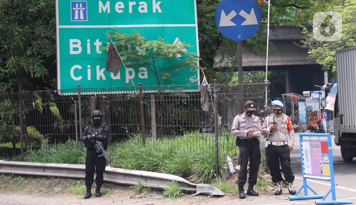 Personel Brimob bersenjata melakukan penjagaan ketat di depan pintu masuk Tol Bitung, Tangerang, Baten, Selasa (6/10/2020). Penjagan ketat dilakukan untuk mengamankan dan mencegah aksi buruh yang akan menggelar aksi menolak UU Cipta Kerja. (Liputan6.com/Angga Yuniar)