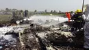 Petugas pemadam berupaya menjinakkan api dari puing-puing pesawat militer berukuran kecil yang jatuh sesaat setelah lepas landas di bandara Kota Naypidaw, Myanmar, Rabu (10/2). Sedikitnya empat orang tewas dalam kecelakaan ini. (AFP/PHOTO/AUNG Htet)
